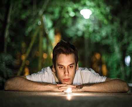 Mindfulness and meditation- Young man gazing at a candle for meditation practice