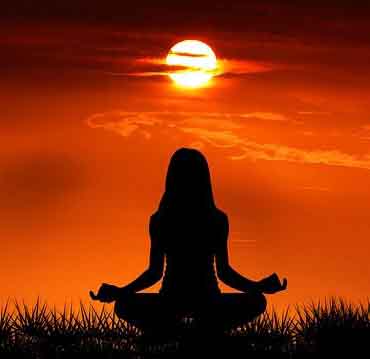 Spiritual people- Woman meditating with red sunset backgraound